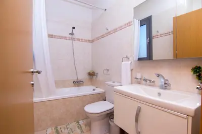 a bathroom with a toilet and a sink and a tub at Haraki Villas in Haraki