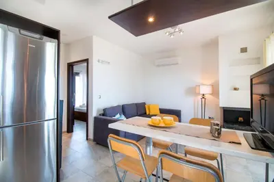 a kitchen and living room with a table and a refrigerator at Haraki Villas in Haraki