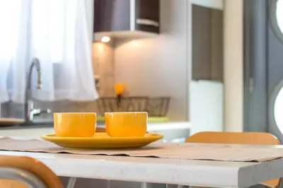 two orange cups on a yellow plate on a table at Haraki Villas in Haraki