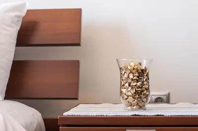 a glass vase filled with coins sitting on a table at Haraki Villas in Haraki