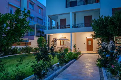 a building with a pathway in front of a yard at Monte Smith Luxury Garden Apartment With Parking in Rhodes Town