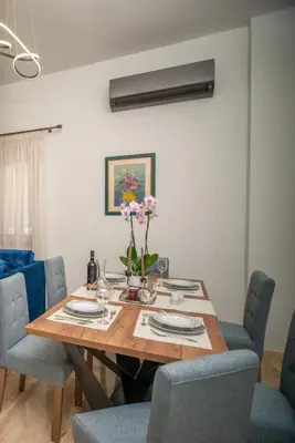 a dining room table with chairs and flowers on it at Monte Smith Luxury Garden Apartment With Parking in Rhodes Town