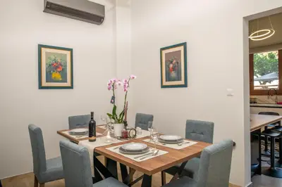 a dining room with a wooden table and chairs at Monte Smith Luxury Garden Apartment With Parking in Rhodes Town