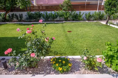 a garden with pink roses in a yard at Monte Smith Luxury Garden Apartment With Parking in Rhodes Town