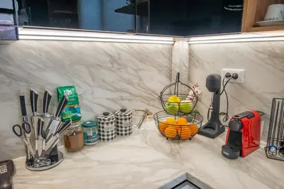 a counter with utensils and a basket of oranges on it at Monte Smith Luxury Garden Apartment With Parking in Rhodes Town