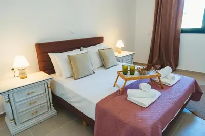 a bedroom with a bed and two tables with towels at Anemoessa Mansion in Rhodes Town