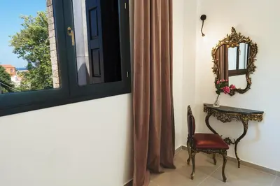a room with a window and a chair and a mirror at Anemoessa Mansion in Rhodes Town