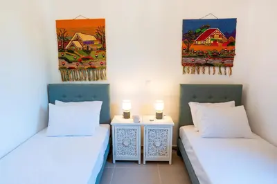 two beds in a room with paintings on the wall at Anemoessa Mansion in Rhodes Town