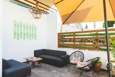 a living room with a couch and chairs and an umbrella at Anemoessa Mansion in Rhodes Town