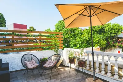 a patio with two chairs and an umbrella at Anemoessa Mansion in Rhodes Town