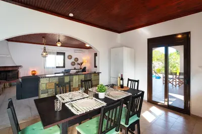 a dining room and kitchen with a table and chairs at Villas Mina and Studios in Gennadi