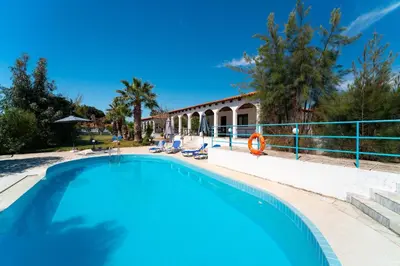 a swimming pool in front of a house at Villas Mina and Studios in Gennadi