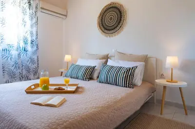a bed with a tray of food and drinks on it at Villas Mina and Studios in Gennadi