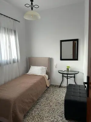 a small bedroom with a bed and a table at Old Town Villa in Rhodes Town