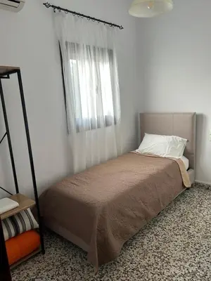 a small bedroom with a bed with a window at Old Town Villa in Rhodes Town