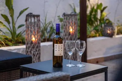 a bottle of wine and two wine glasses on a table at Old Town Villa in Rhodes Town