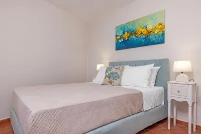 a bedroom with a bed and a painting on the wall at Nikolas Old Town in Rhodes Town