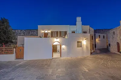 a white building with a door on it at night at Nikolas Old Town in Rhodes Town