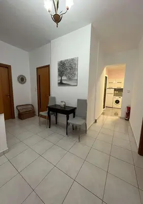 a living room with a table and chairs on a tile floor at Agapi's Seaside Place in Faliraki