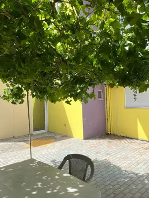 a table and a chair in front of a building at Agapi's Seaside Place in Faliraki