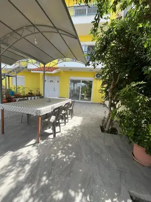 a patio with a table and chairs and an umbrella at Agapi's Seaside Place in Faliraki