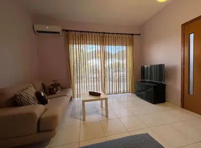 a living room with a couch and a tv at Agapi's Seaside Place in Faliraki