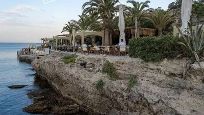 a restaurant on a cliff next to the water at Agapi's Seaside Place in Faliraki