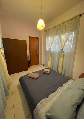 a bedroom with a large bed with two bags on it at Agapi's Seaside Place in Faliraki
