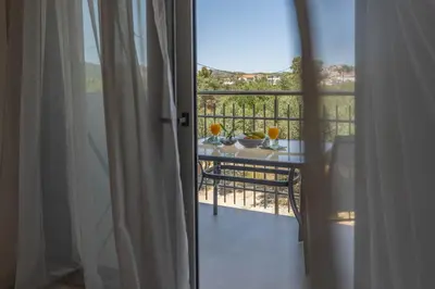 a view of a balcony with a table with glasses on it at Demiani House in Lardos