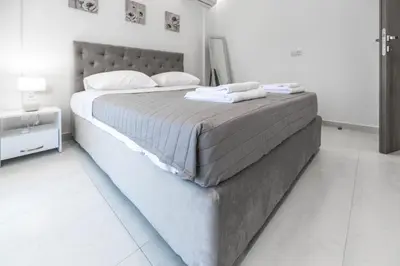 a large bed in a white room with a white floor at Demiani House in Lardos
