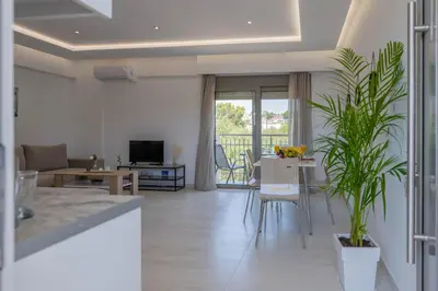 a living room with a table and a dining room at Demiani House in Lardos