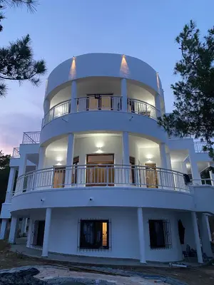 a large white building with a round top at Kallithea Residence in Koskinou