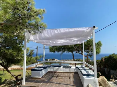 a white gazebo with a view of the ocean at Kallithea Residence in Koskinou