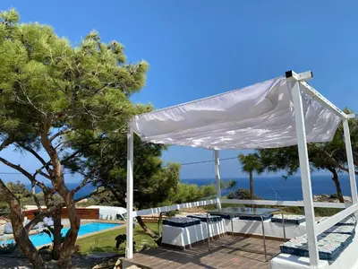 a white gazebo next to a swimming pool at Kallithea Residence in Koskinou