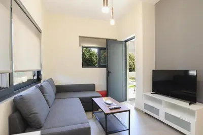 a living room with a couch and a flat screen tv at Green Villa in Ialyssos