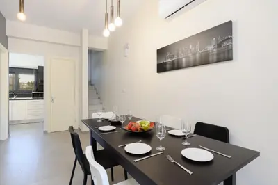 a dining room with a black table and chairs at Green Villa in Ialyssos