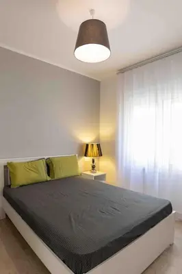a bedroom with a bed with a lamp and a window at Luxury cozy appartment in the city center in Rhodes Town