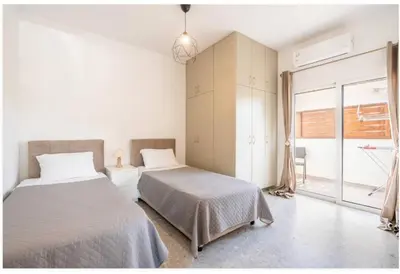 a bedroom with two beds and a window at Restaurant Maria Suites SunSet in Faliraki