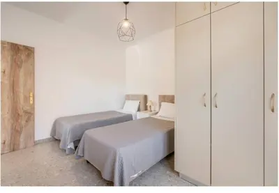 two beds in a room with white cabinets at Restaurant Maria Suites SunSet in Faliraki