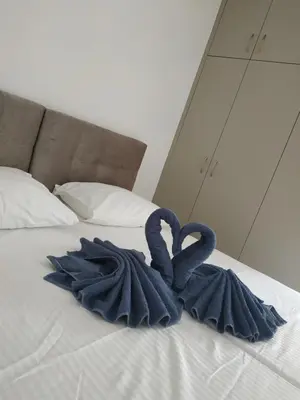 a bed with two towels in the shape of hearts at Restaurant Maria Suites SunSet in Faliraki