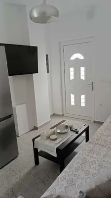 a room with a bed and a table and a door at Restaurant Maria Suites SunSet in Faliraki