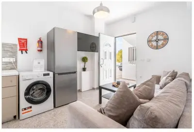 a living room with a couch and a washing machine at Restaurant Maria Suites SunSet in Faliraki