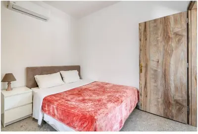 a bedroom with a bed and a wooden door at Restaurant Maria Suites SunSet in Faliraki