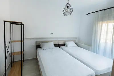 two beds in a room with white walls at Rhodes City Center Apartments in Rhodes Town