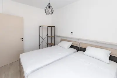 two beds in a room with white walls at Rhodes City Center Apartments in Rhodes Town