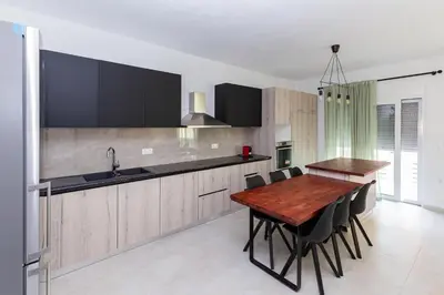 a kitchen with a wooden table and black chairs at Rhodes City Center Apartments in Rhodes Town