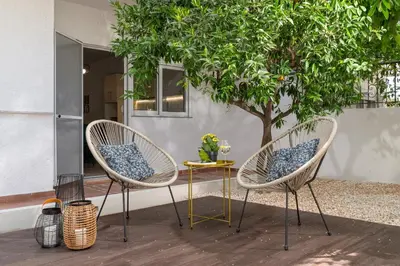two chairs and a table in front of a tree at Klinon Asti city apartment in Rhodes Town