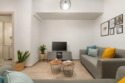 a living room with a couch and a tv at Klinon Asti city apartment in Rhodes Town