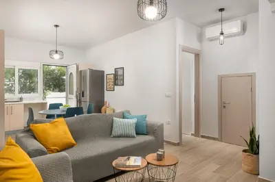 a living room with a gray couch and a kitchen at Klinon Asti city apartment in Rhodes Town