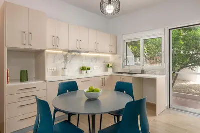 a kitchen with a table and blue chairs at Klinon Asti city apartment in Rhodes Town